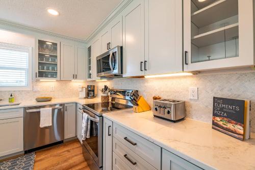 a kitchen with white cabinets and stainless steel appliances at MoonDance OBX - D3135 in Port Trinitie