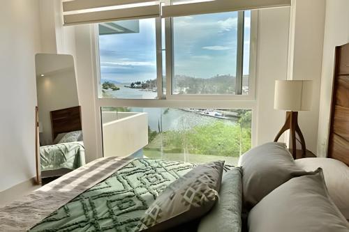 a bedroom with a bed and a large window at Altamar in Nuevo Vallarta 