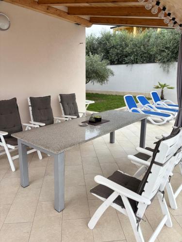 a gray table and chairs on a patio at Villa Silver Novigrad with private pool in Novigrad Istria