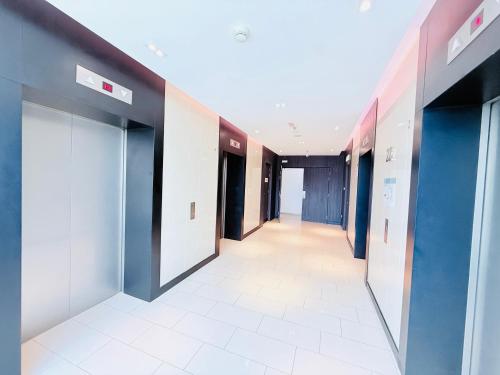 an empty hallway of an office with blue and white doors at The Luxe By klcc infinitum in Kuala Lumpur
