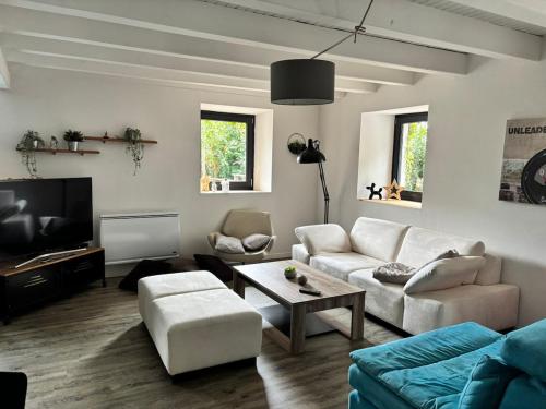 a living room with a couch and a tv at Maison en lisière de forêt, montagne et vignobles in Rammersmatt