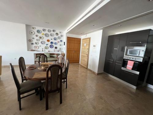 a kitchen and dining room with a table and chairs at Mahdia with sea view in Hiboun