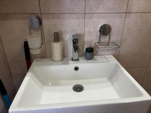 a white sink in a small bathroom with at АпартаменЪТ у Град in Belogradchik