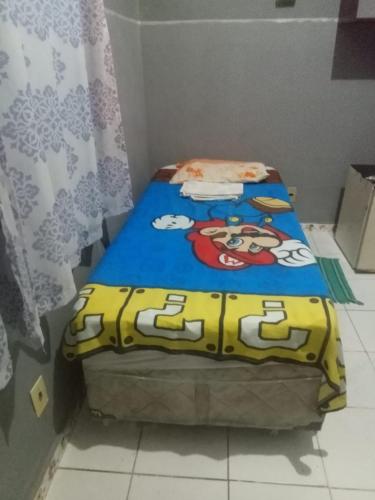 a bedroom with a bed with a mickey mouse blanket at Quarto - Room de hóspedes da Menina Maricotinha 2 in Manaus