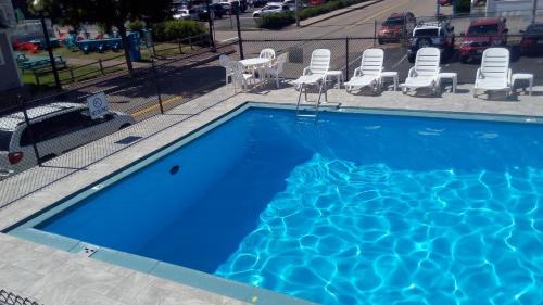 a large blue swimming pool with chairs at Mt Royal Motel in Old Orchard Beach