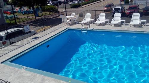 einen großen blauen Pool mit Stühlen in der Unterkunft Mt Royal Motel in Old Orchard Beach