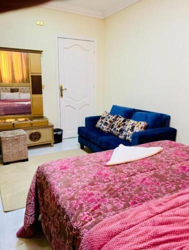 a bedroom with a bed and a blue couch at Eyad Pyramids view in Cairo