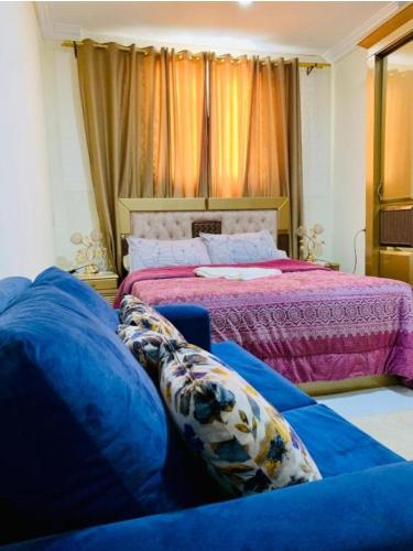 a bedroom with a bed and a blue couch at Eyad Pyramids view in Cairo