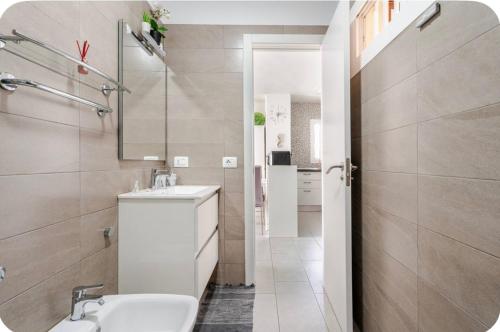 een badkamer met een wastafel, een toilet en een spiegel bij Exclusive ocean front apartment in Playa de las Americas