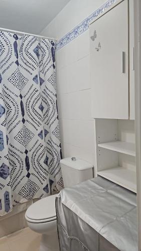 a bathroom with a toilet and blue and white wallpaper at Los Cancajos Apartamento Acijoa in Los Cancajos