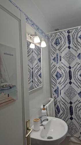 a bathroom with a sink and a blue and white patterned wall at Los Cancajos Apartamento Acijoa in Los Cancajos