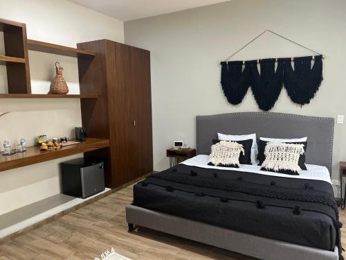 a bedroom with a large bed with black sheets and pillows at UTSKIN By ZENDA - Luxury Villas & Private Pools in Tulum