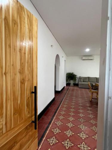 a hallway with a wooden door and a living room at Surfer Grill Accommodation - Pradomar PC Experience in Puerto Colombia