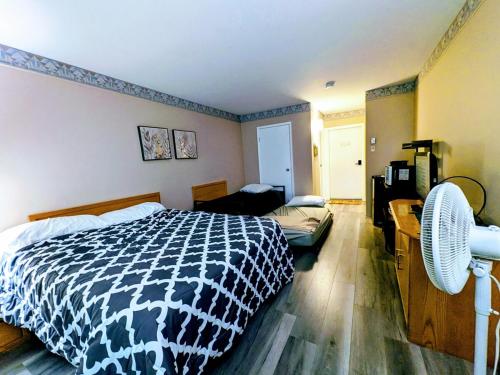 a bedroom with a black and white bed and a couch at Tremblant Hideaway, Ski & Golf Retreat in Mont-Tremblant