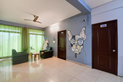 a living room with a painting of a dog on the wall at Hotel O Urban Legends in Bārang