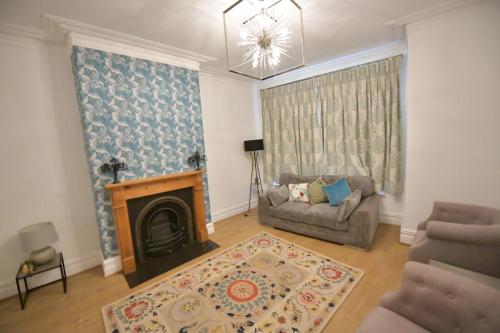 a living room with a couch and a fireplace at Charming & Cosy Home Stockport in Stockport