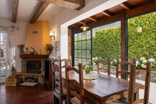 a dining room with a wooden table and a large window at Casa da Avo in Faial