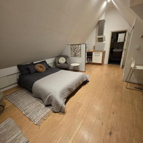 a bedroom with a bed and a chair on a wooden floor at Prince On The Roof in Amsterdam