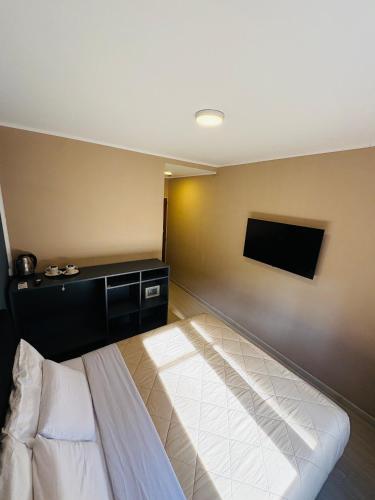 a bedroom with a bed and a flat screen tv at Hotel Espacio Buenos Aires in Buenos Aires