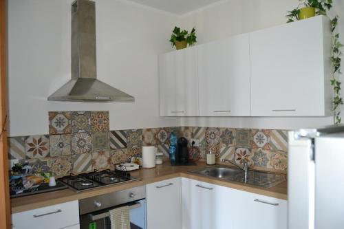 a kitchen with white cabinets and a sink at Guest Room Nesea in Pellaro