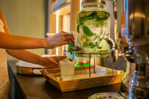 a person is making a drink in a blender at Hotel San Giorgio Resort 4S in Caorle