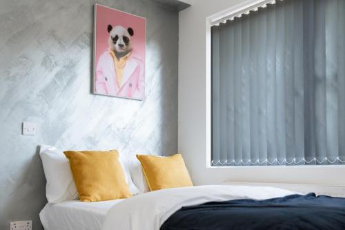 a bedroom with a bed and a painting of a dog at Spacious En-Suite Double Room near Coventry Uni & Hospital in Wyken