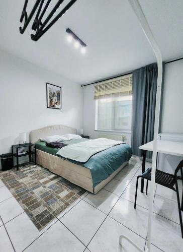 a bedroom with a bed and a table and a desk at Mila's Cosy Place in Boortmeerbeek