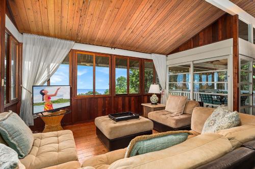 a living room with a couch and a tv at Orchid Hale in Kailua-Kona