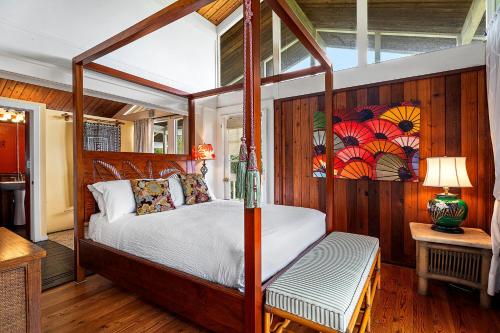 a bedroom with a canopy bed in a room at Orchid Hale in Kailua-Kona