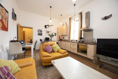 a living room with a couch and a table and a kitchen at The Avenue in Leamington Spa