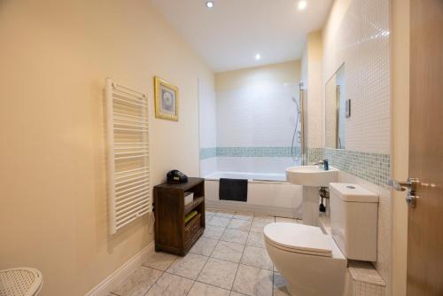 Un baño con inodoro, bañera y lavabo. en The Avenue, en Leamington Spa
