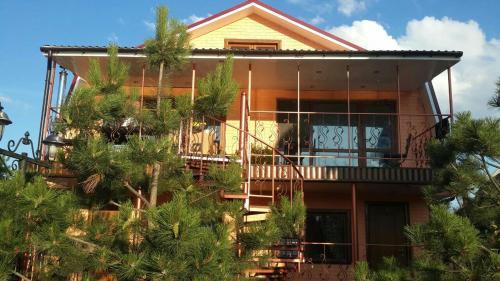 a house with palm trees in front of it at Villa Sosnovy Bor in Zatoka