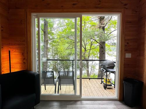 a room with a sliding glass door with a patio at 1-bedroom Unique Eco Log Cabins in Parry Sound #103 in Parry Sound