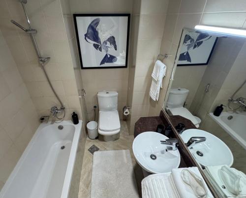 ein Badezimmer mit Badewanne, Waschbecken und Toilette in der Unterkunft Big studio, Dubai SportCity, parking included in Dubai