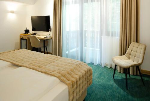 a hotel room with a bed and a desk and a television at Hotel Regal in Sinaia