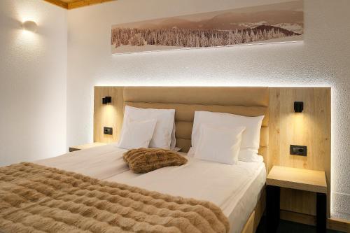 a bed with a cat laying on top of it at Hotel Regal in Sinaia