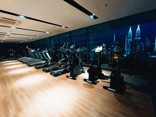a gym with rows of treadmills and a city at The Luxe By klcc infinitum in Kuala Lumpur