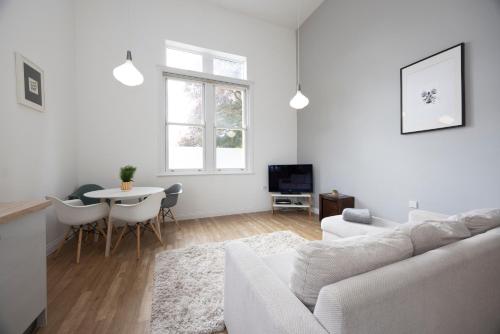 a white living room with a white couch and a table at The Avenue in Leamington Spa