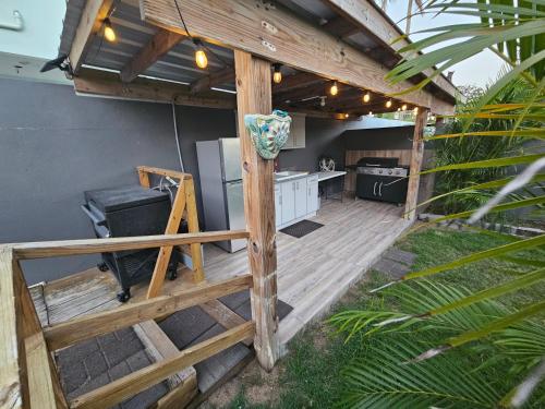 an outdoor kitchen with a wooden deck with a grill at Pelican Dock Apartments in Aguada