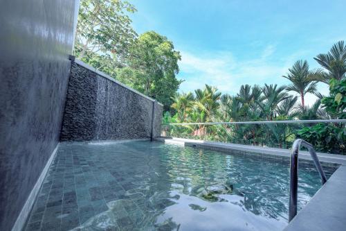a swimming pool with a waterfall in a backyard at Sunset Family Package Units 304 & 305 in Jacó