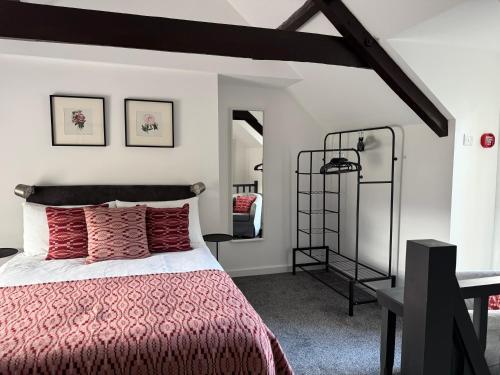 a bedroom with a bed with a red comforter at 12 Crickhowell Cottages, Town Centre Location in Crickhowell