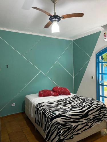 a bedroom with a bed with a ceiling fan at Flow Hostel Juquehy in Juquei