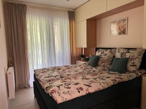a bedroom with a large bed with a large window at Apartament Virgo in Międzyzdroje