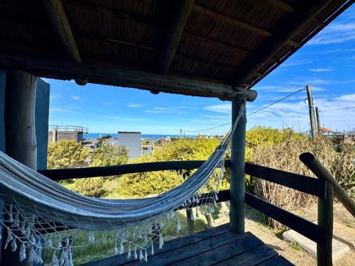 a hammock on a porch with a view at Complejo Las Carmelas in Punta Del Diablo