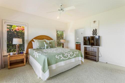 a bedroom with a bed and a flat screen tv at Mahi Iulani in Kailua-Kona