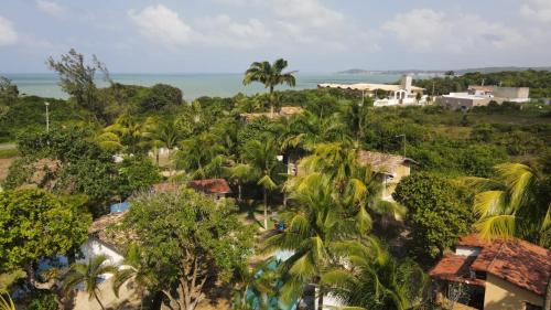 an aerial view of a resort with palm trees and the ocean at Pousada Cacimbinha in Pipa