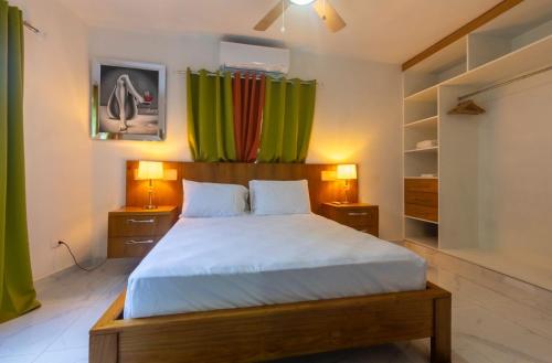 a bedroom with a bed with two night stands and two lamps at Litzie Apartment in San Felipe de Puerto Plata
