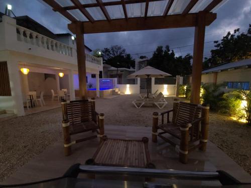a patio with two chairs and an umbrella at night at Litzie Apartment in San Felipe de Puerto Plata