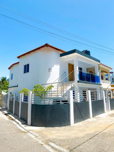 a white house with a fence in front of it at Litzie Apartment in San Felipe de Puerto Plata