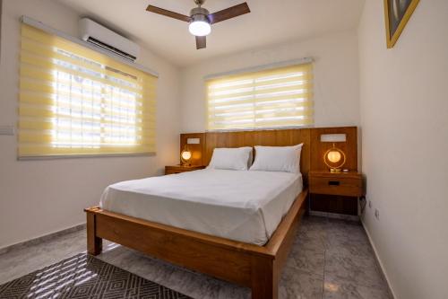 a bedroom with a bed and two windows at Litzie Apartment in San Felipe de Puerto Plata